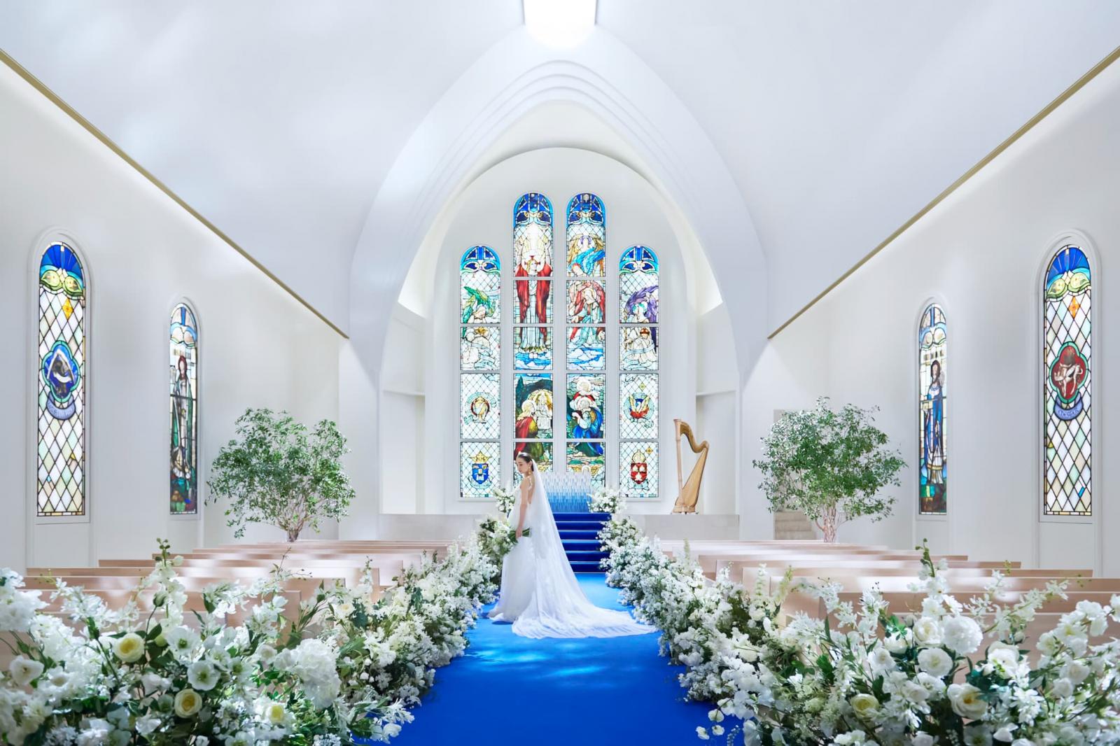 ロイヤルブルーのバージンロード。純白のウェディングドレスが美しく映り、刺繍が浮かび上がります。<br />
生まれ変わったアニヴェルセル 表参道の大聖堂チャペル。