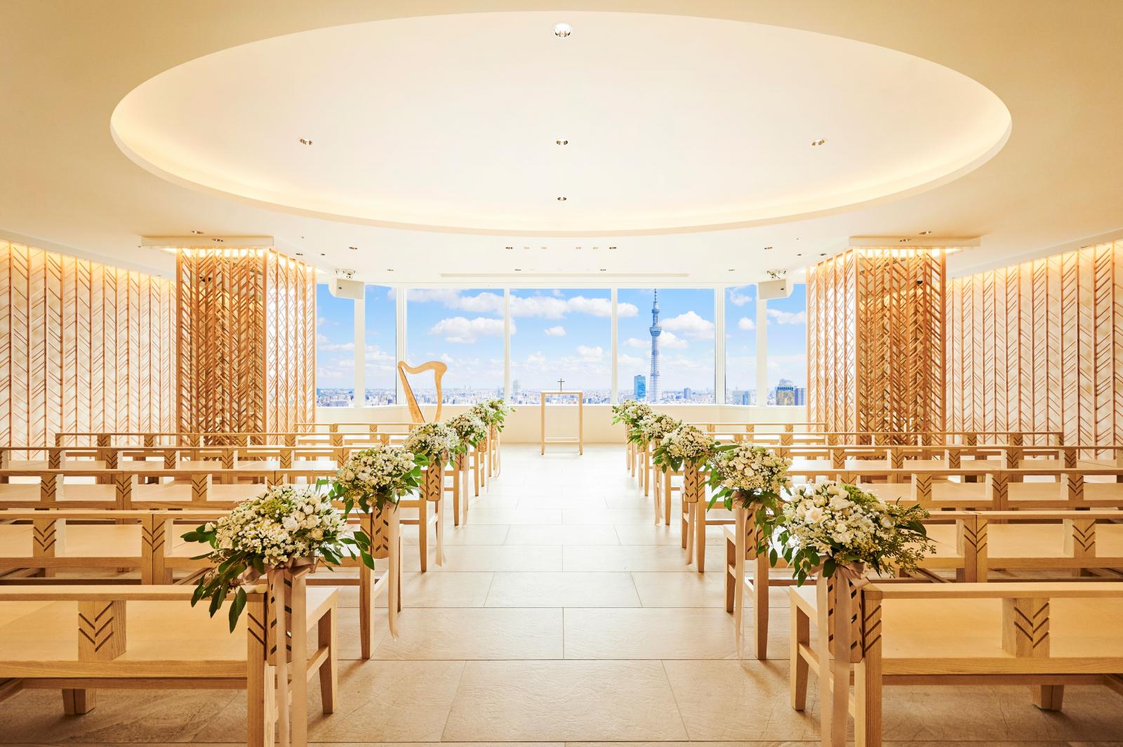 地上100mのスカイチャペルが「ナチュラルモダン」をテーマにオープン<br />
果てしなく続く空の中で永遠の愛を誓う心に刻まれるウェディングシーンを