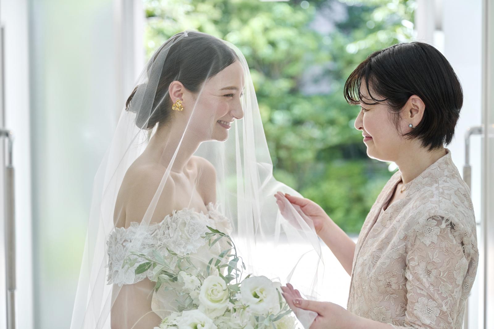 白亜のチャペルの中で家族に祝福されながら行うベールダウンは大切なひととき