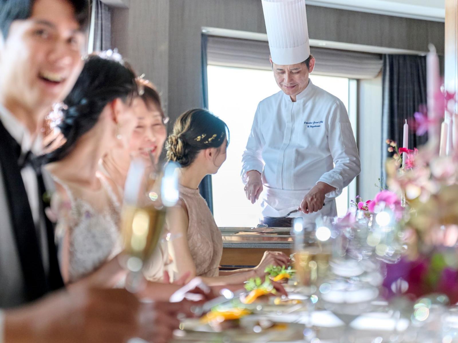 スイートルームに家族を招き、お部屋でお食事会。隣では、シェフが皆さまのためだけに料理の仕上げを。会話を愉しみながら自由に過ごせる最上ウエディング