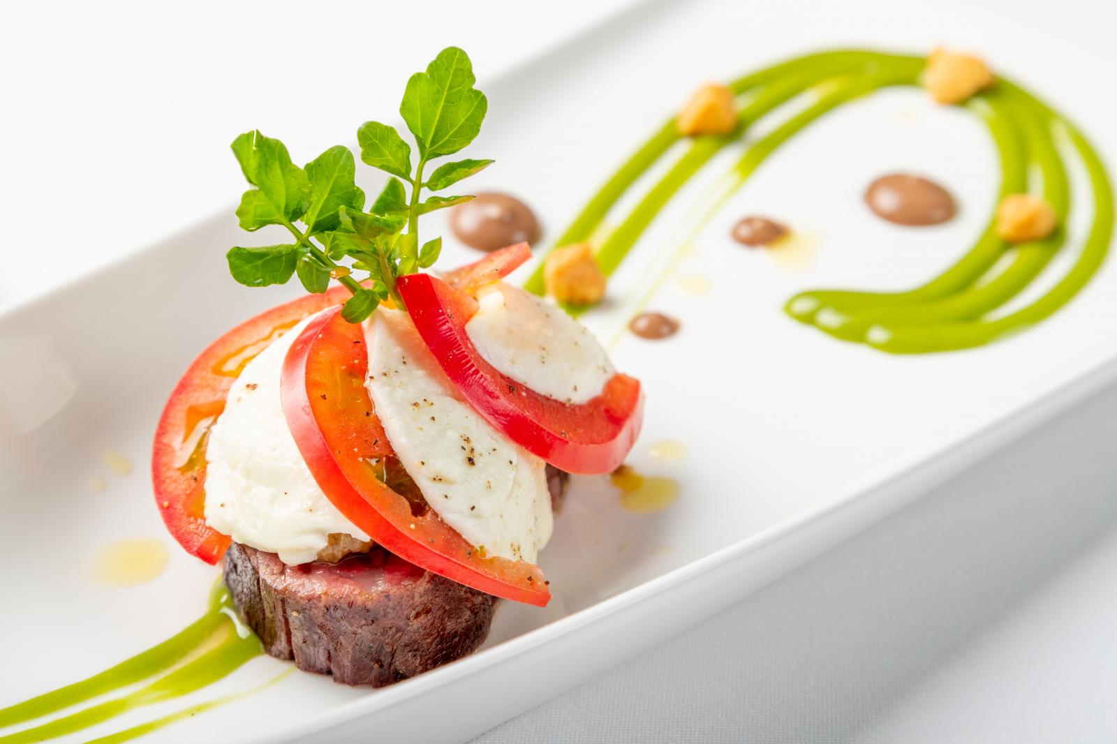 トマトとモッツァレラチーズを薔薇のように盛り付けた、彩り豊かなお料理
