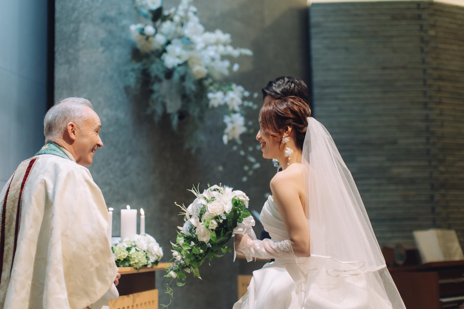 専任牧師と新郎新婦が式中に笑顔で顔を見合わせる、そんな特別な信頼関係でつくり上げられる挙式