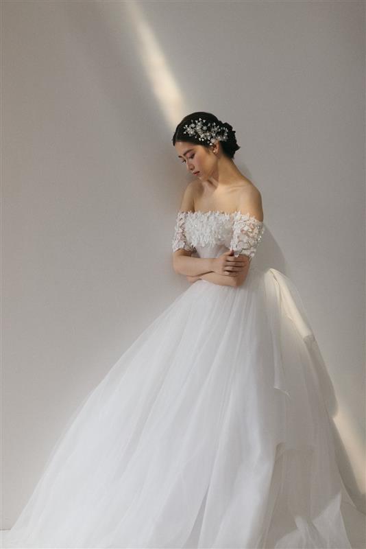 繊細なレースが肩を彩りやわらかな光が調和する、優美で愛される花嫁姿