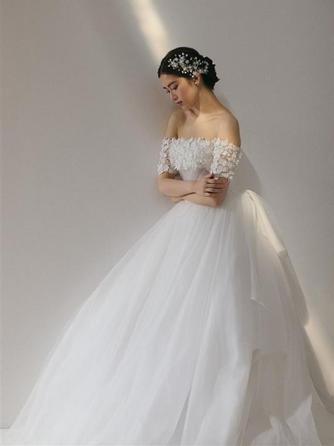 繊細なレースが肩を彩りやわらかな光が調和する、優美で愛される花嫁姿