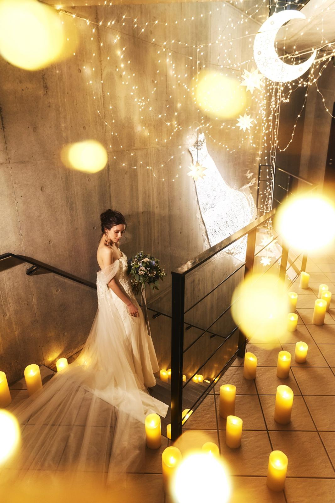 光のオブジェが印象的なホワイエに続く階段にキャンドルを飾れば期待値がさらに高まる