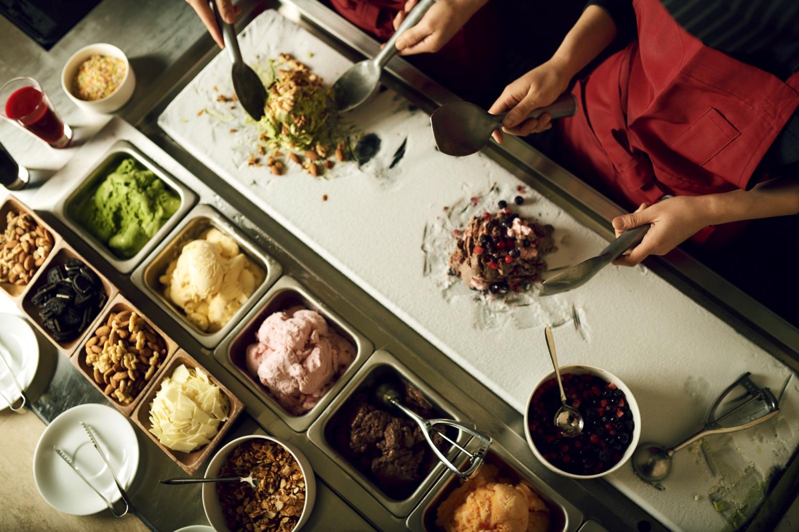 冷えた石板の上でフルーツやアイスクリームをへらを使ってこねるストーンアイス