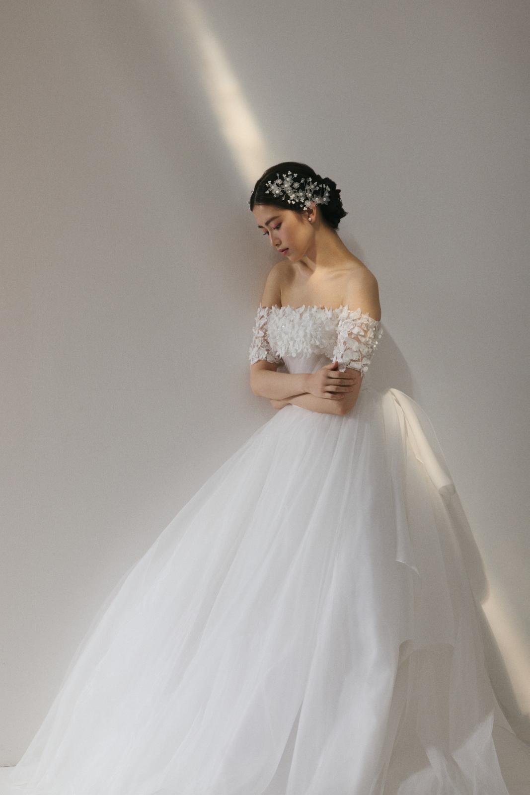 繊細なレースが肩を彩りやわらかな光が調和する、優美で愛される花嫁姿