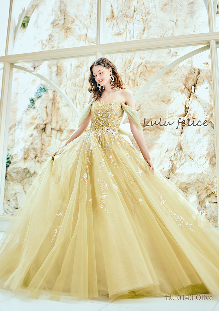 ボタニカルモチーフを纏ったイエローのドレス。スカートに広がるグリッターの刺繍が華やか