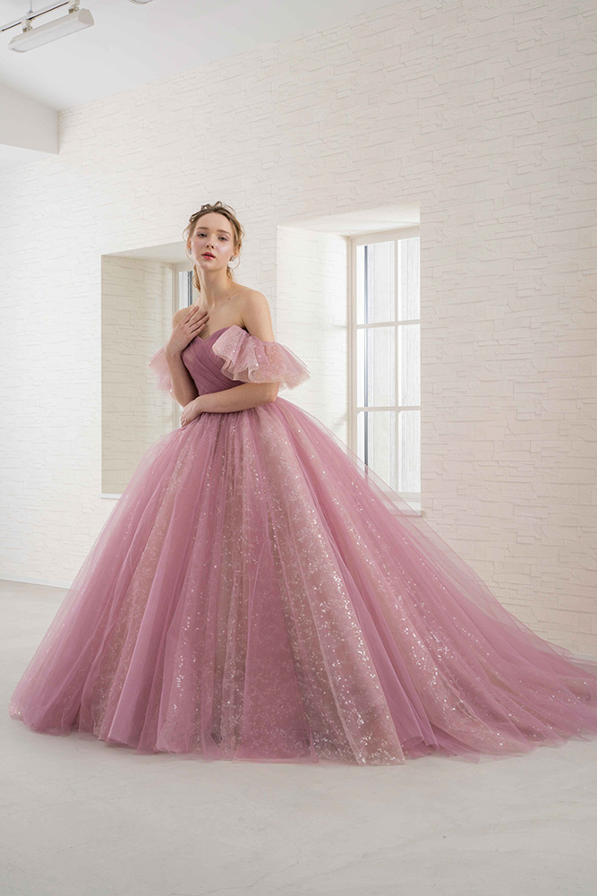 ボタニカルモチーフを纏ったイエローのドレス。スカートに広がるグリッターの刺繍が華やか