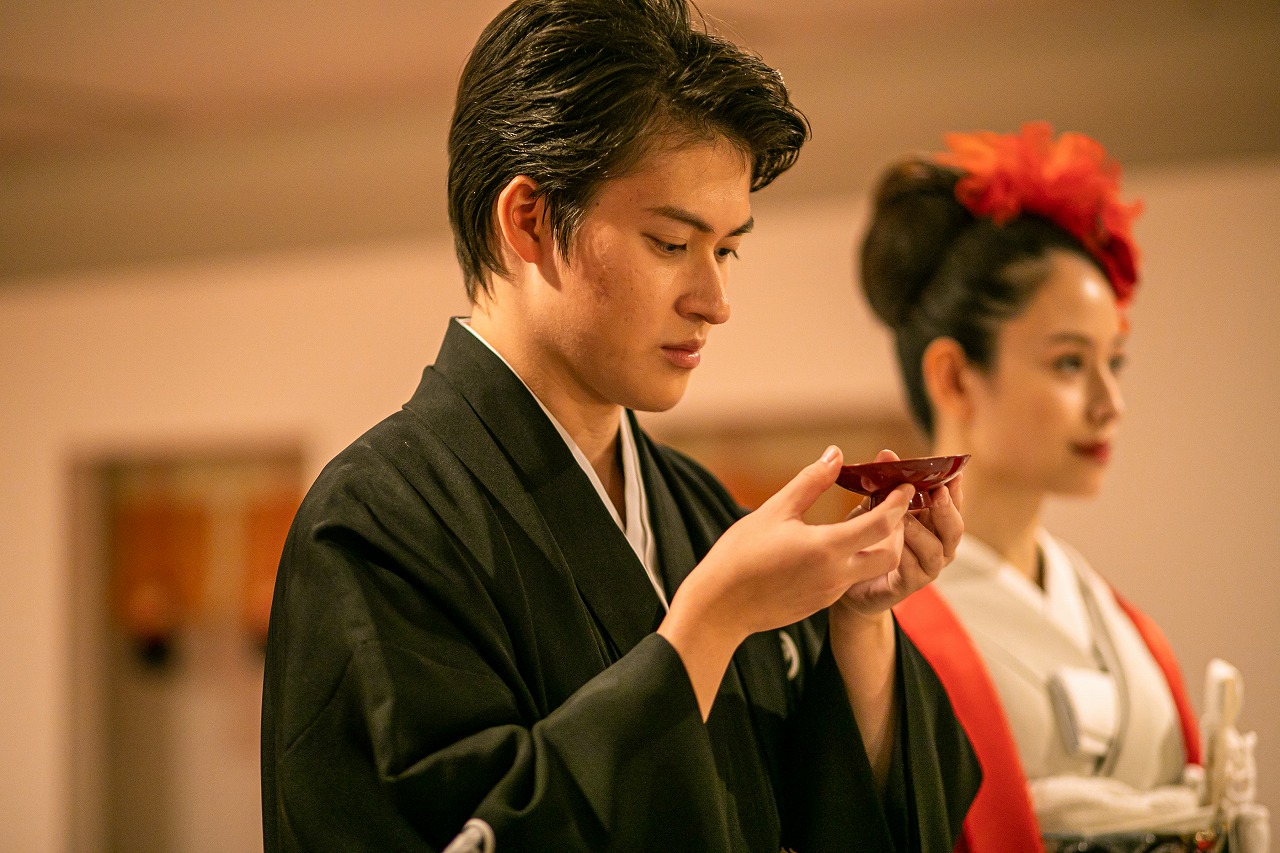 林とした空気の中の厳かな本格結婚式を神殿で。固めの杯を交わす新郎新婦