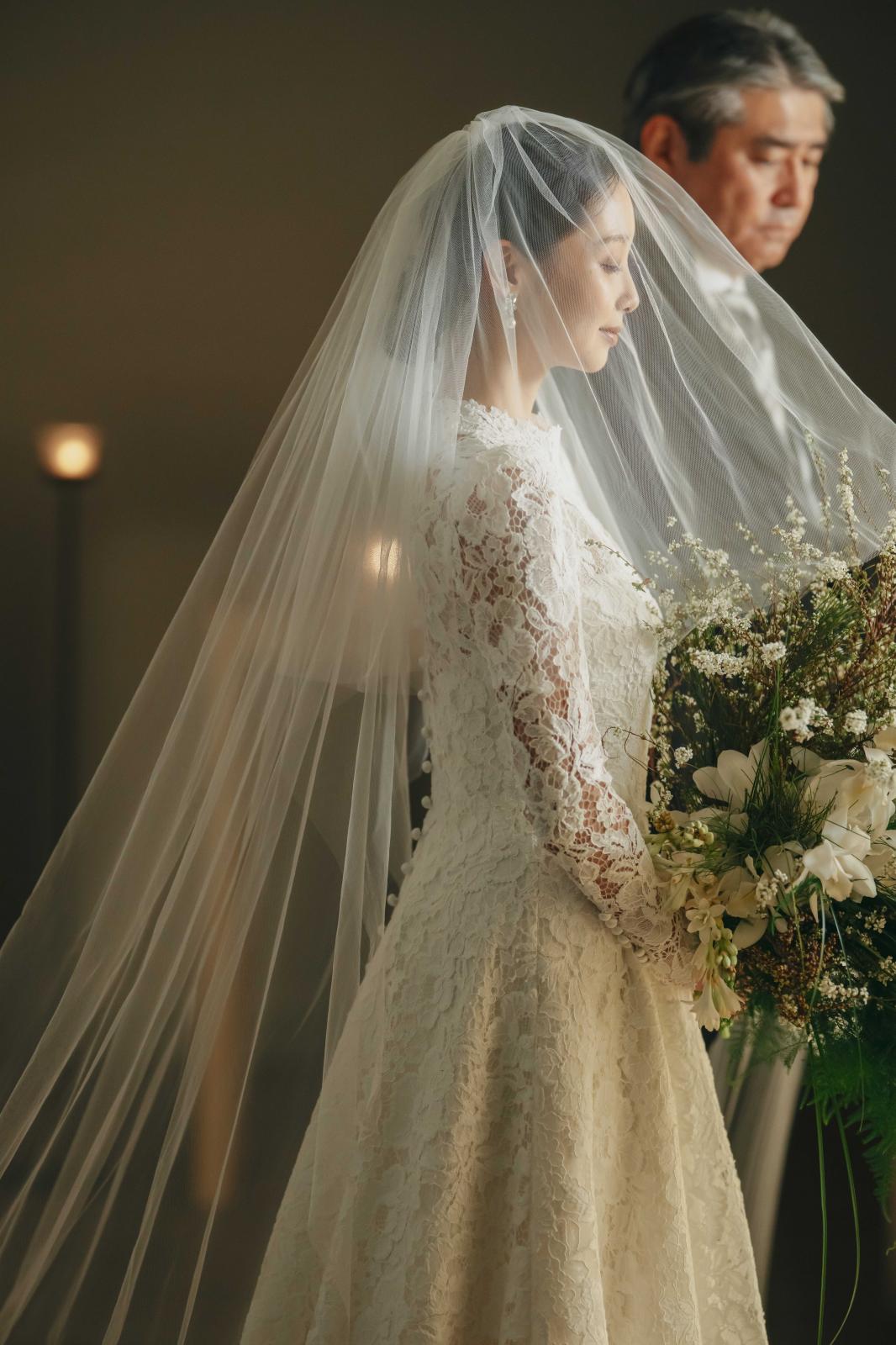 純白のドレスをまとった花嫁を、柔らかい光とキャンドルライトが優しく包み込む。