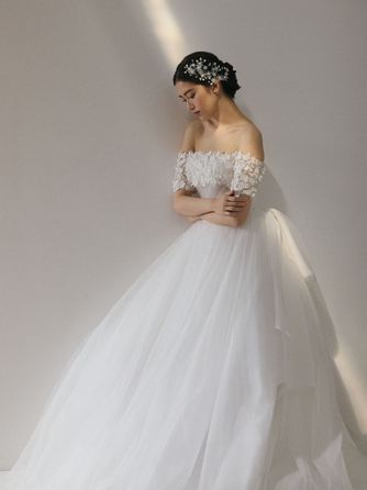 繊細なレースが肩を彩りやわらかな光が調和する、優美で愛される花嫁姿