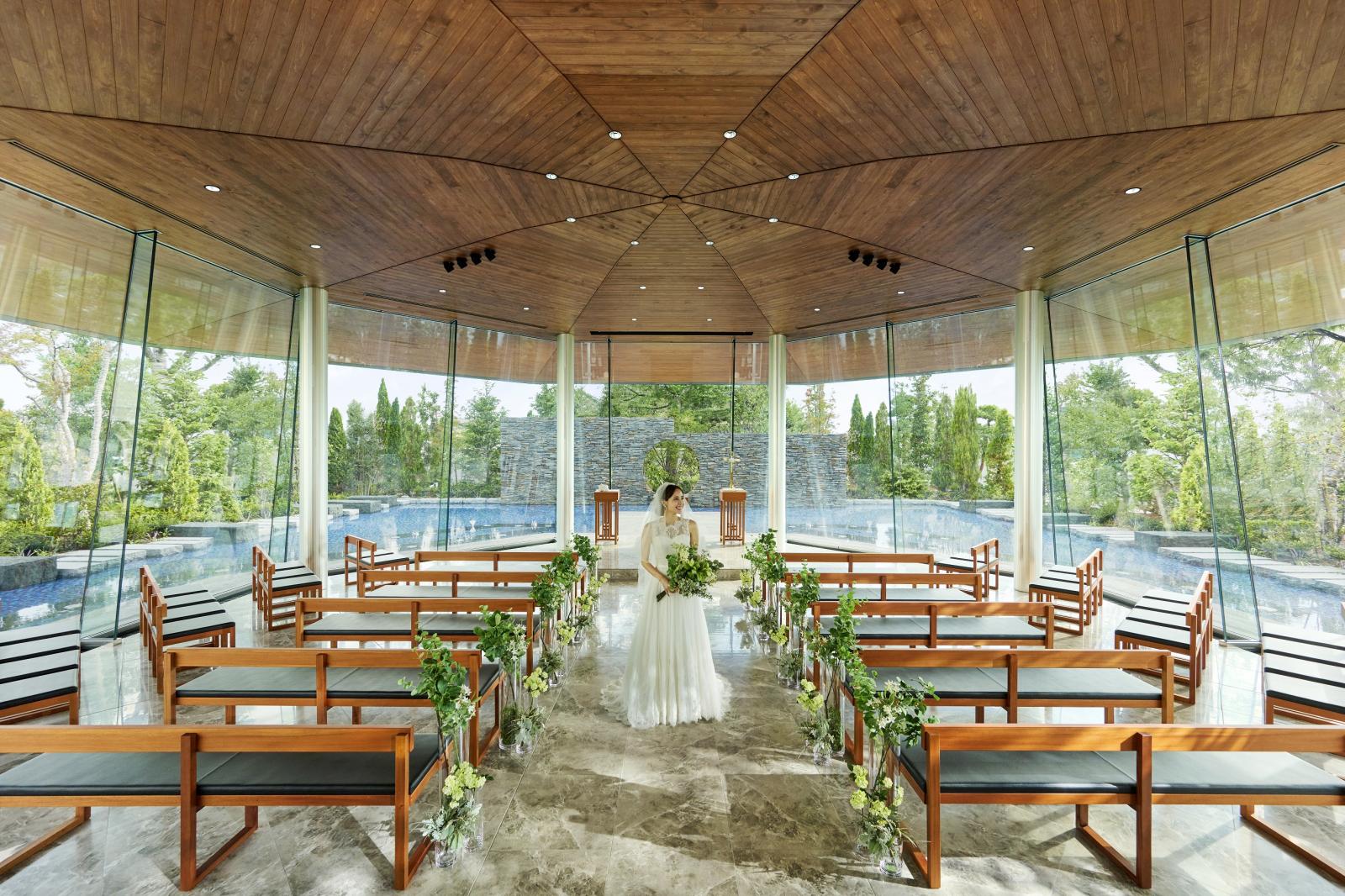 水辺に囲まれたガラス張り八角形の挙式会場　Huit～ユイット～。温かな自然光と緑豊かなガーデンがゲストを迎える。