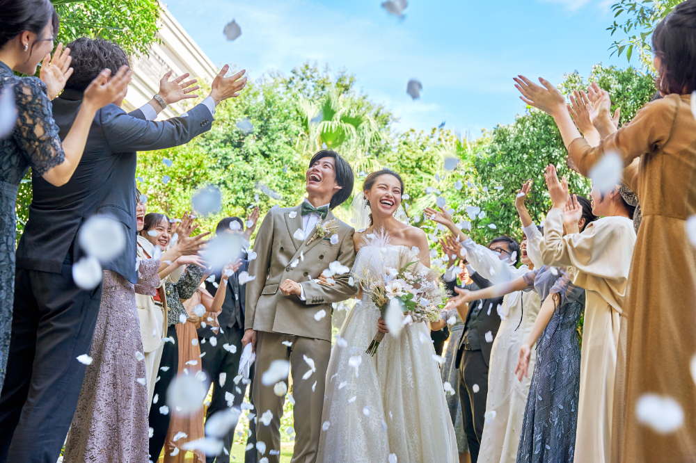 溢れる緑と広がる青空のもと、ゲストからの祝福のフラワーシャワーを