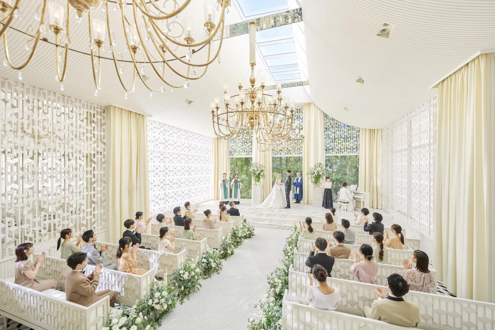 シャンパンゴールドのシャンデリアが煌めく、光と緑に彩られたチャペル。正面は新郎新婦の姿が映えるようグリーンでナチュラル感を演出