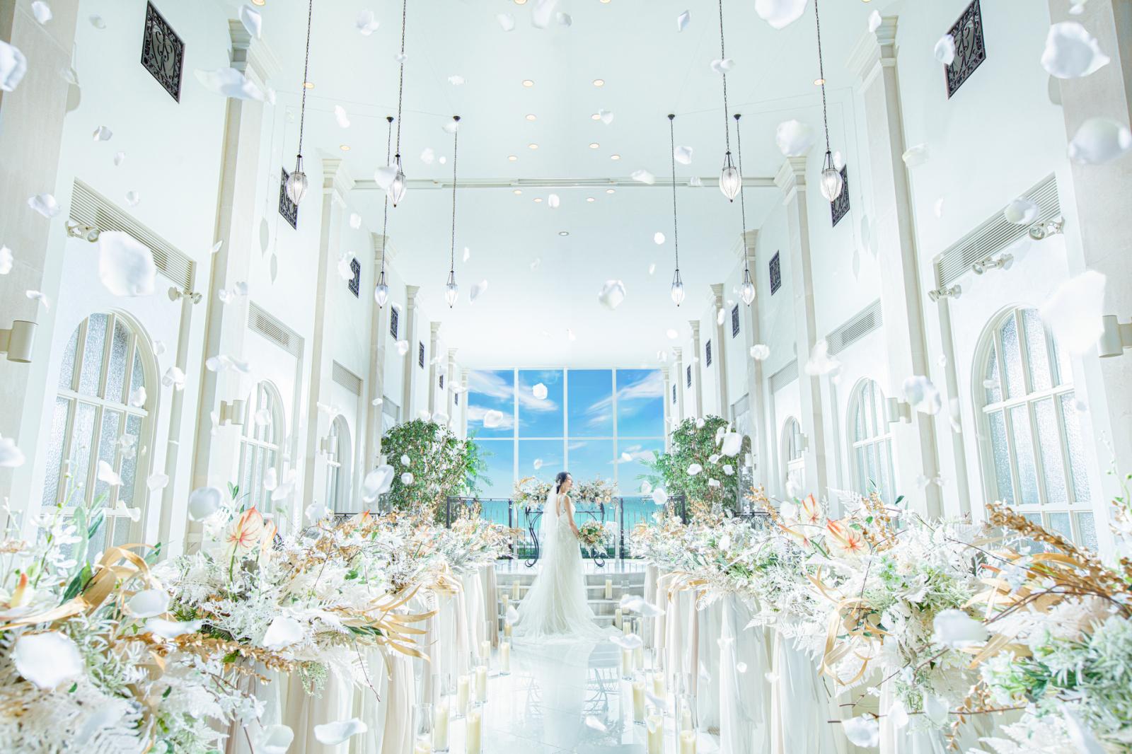 バージンロードの先に、真っ青な海と空が広がる純白チャペル。天候や季節で変わる絶景が、感動の瞬間を彩る