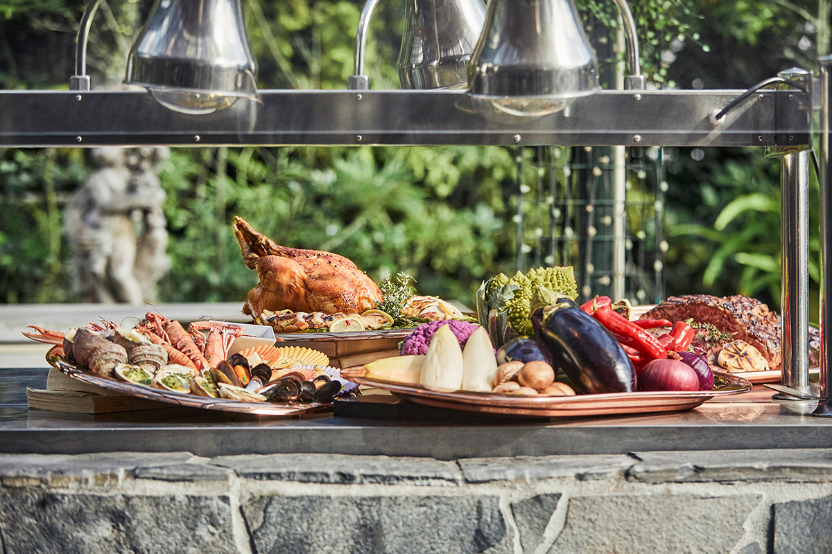 ゲストの目の前で焼き上げるステーキや丸焼きチキン、そしてピザ釜で焼くピザなど、贅沢なライブスタイル