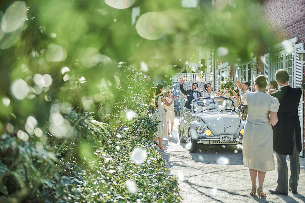 並木道をオープンカーで登場すればゲストからの祝福のフワラーシャワーが待っている