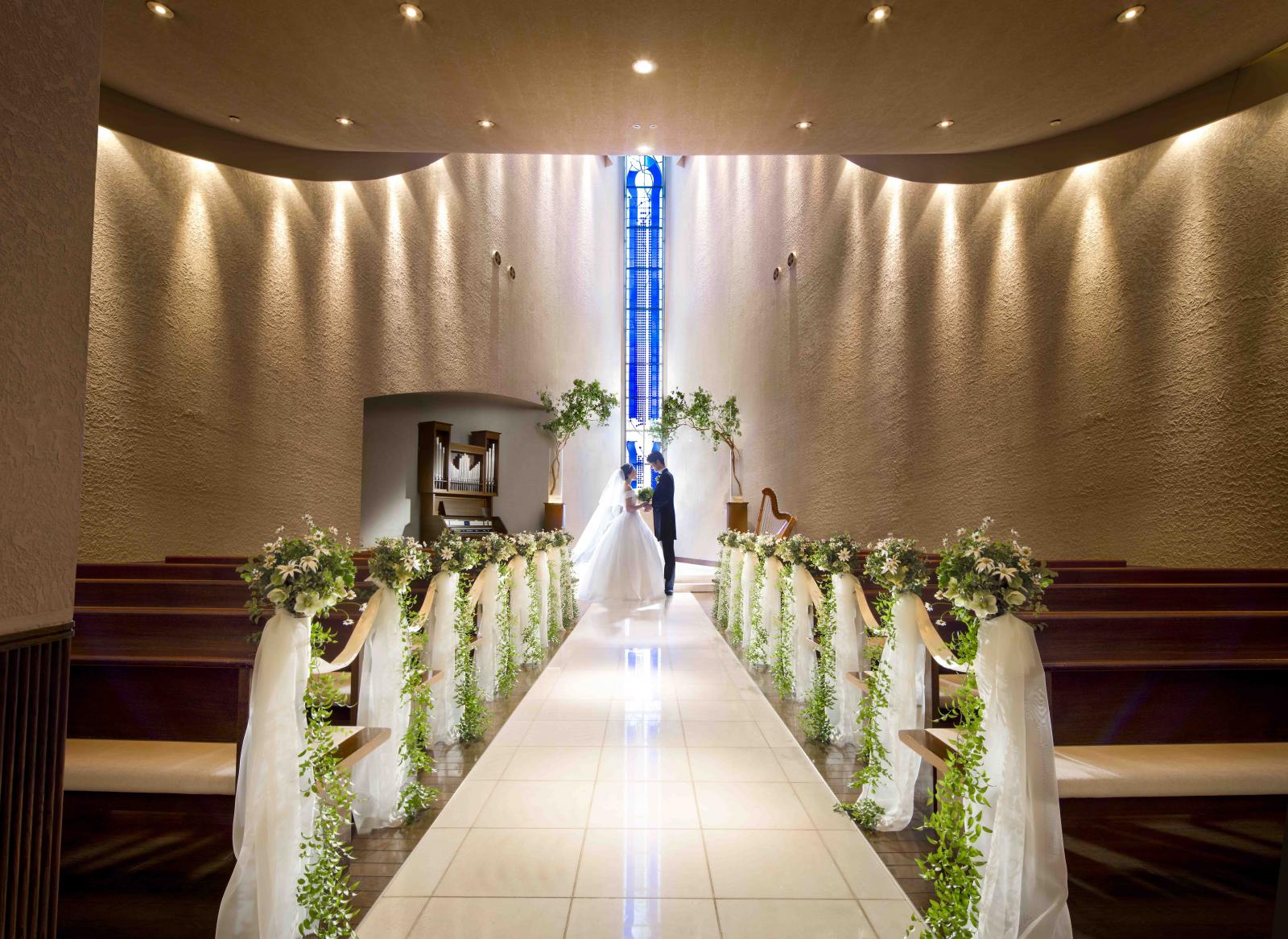 白く輝く大理石のバージンロードと「命の木」をテーマにしたブルーのステンドグラスのコントラストが美しい