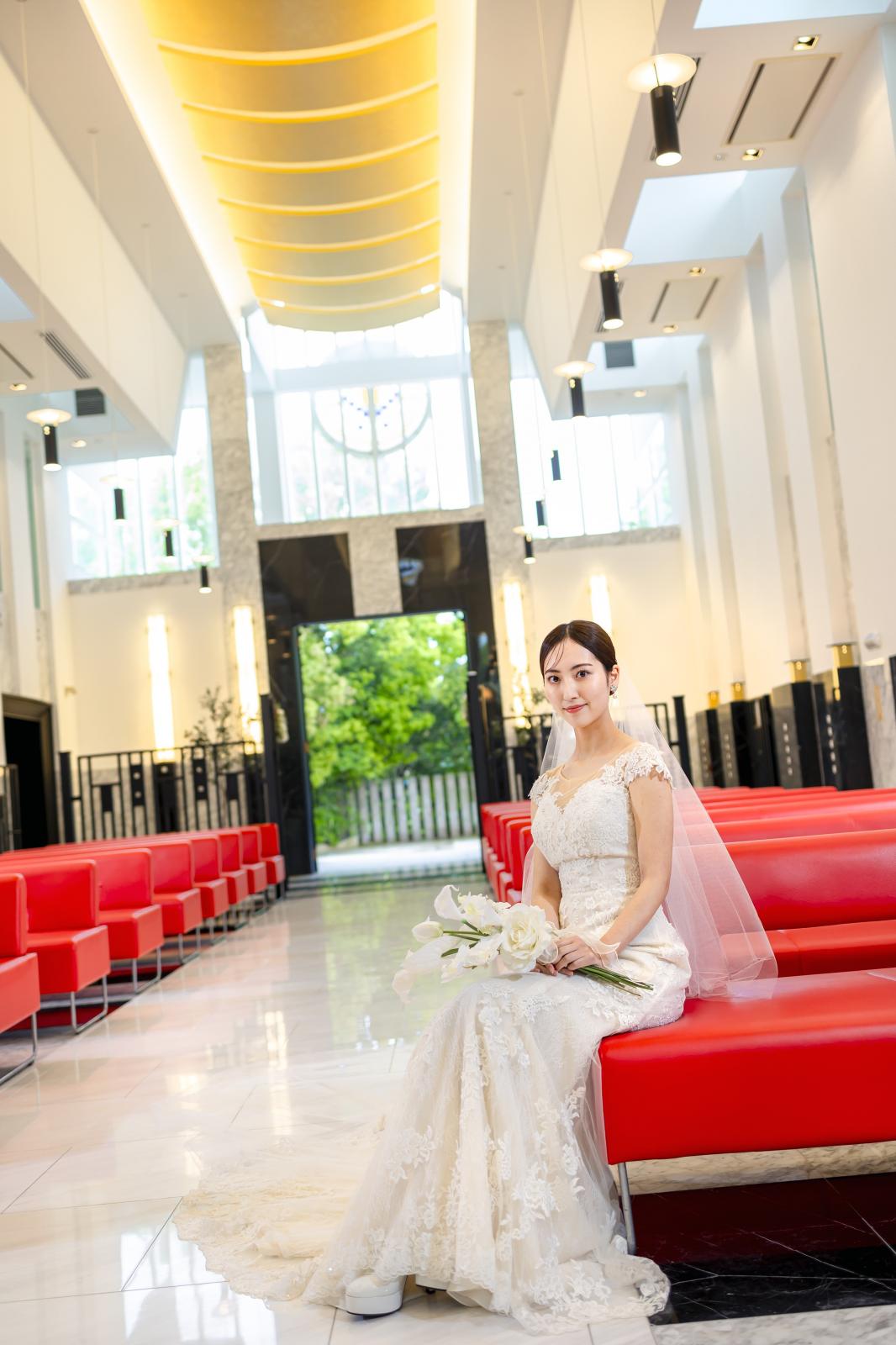 光溢れる白い空間にスカーレットのベンチシートが映えるモダンなチャペル