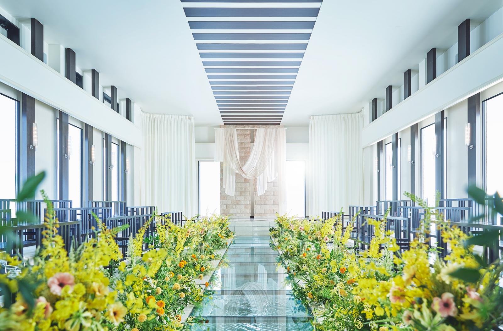 ガラスのバージンロードの下には水が煌めき、リゾート感漂う雰囲気のチャペル。ゲストが対面式に着席するスタイルは滋賀で唯一。どの席からもふたりの姿を見守ることが出来るので、温かい雰囲気の中結婚式が進行する