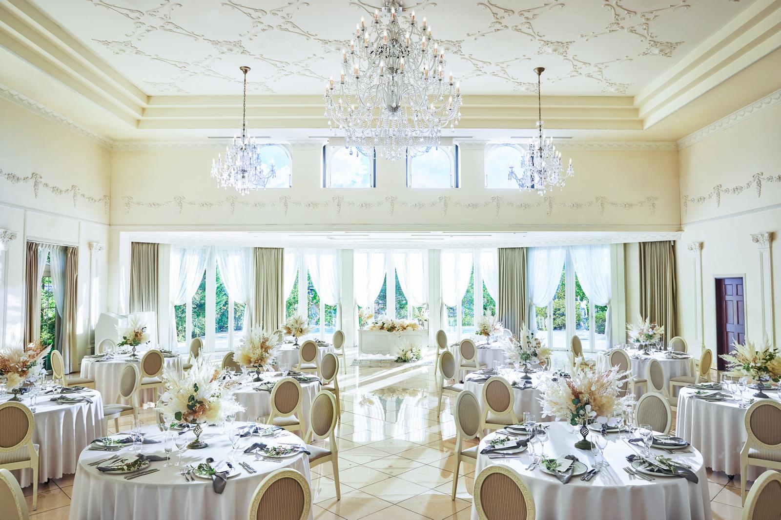 中央のシャンデリアがひときわ目を引くバンケット。純白の会場はふたりの好みに合わせてコーディネートも自由自在。プール付きプライベートガーデンが隣接していて演出の幅も広がる