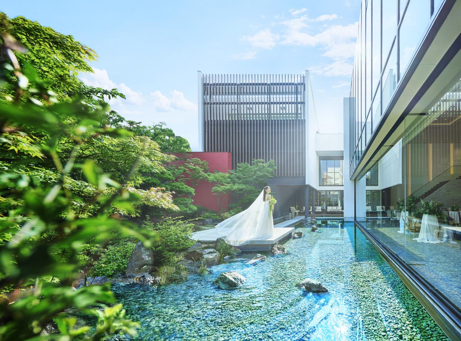 能舞台にみたてた石舞台と煌く水面に緑が映える美空間