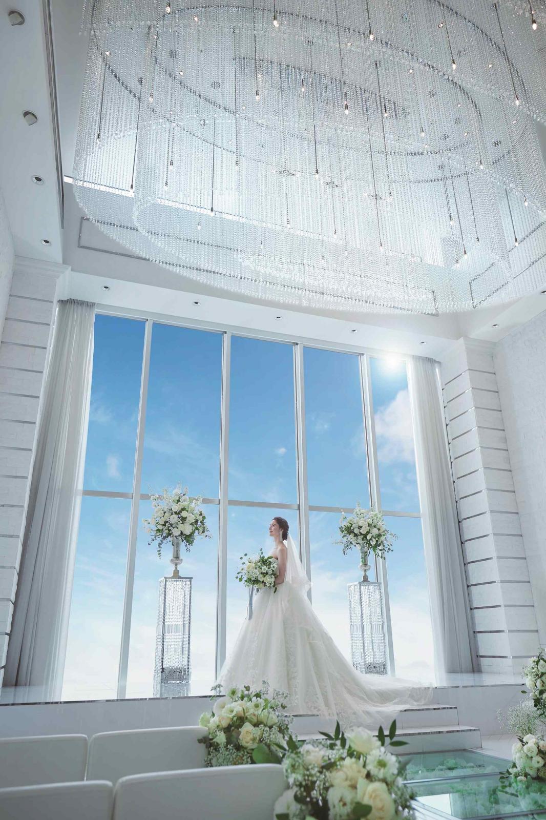 祭壇奥には天井まで届く大きな1面窓からは自然光が降り注ぎ、チャペル全体を優しく包み込む神聖な空間