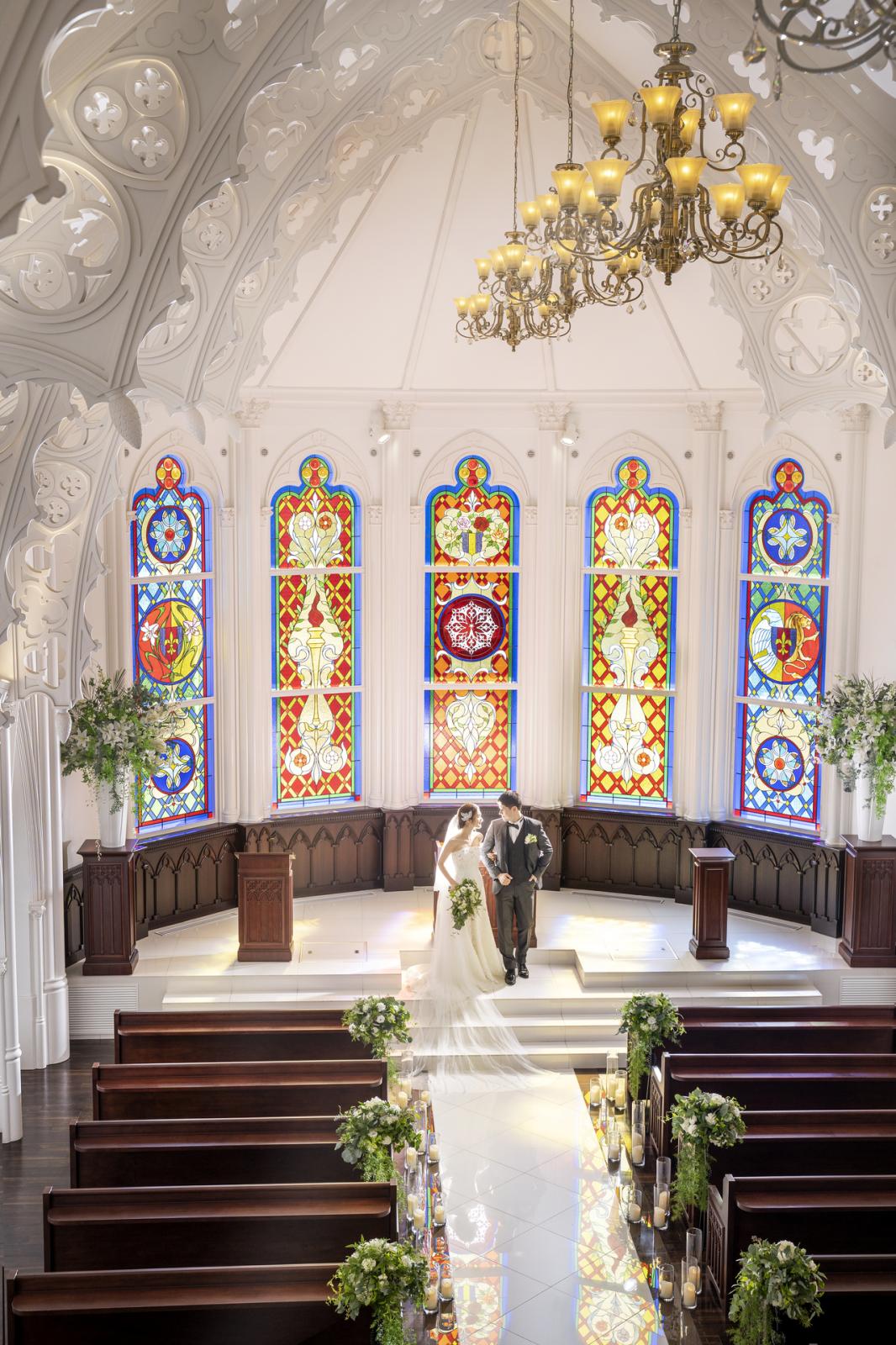 オーダーメイドのステンドグラスから差し込む光がおふたりを照らし出す