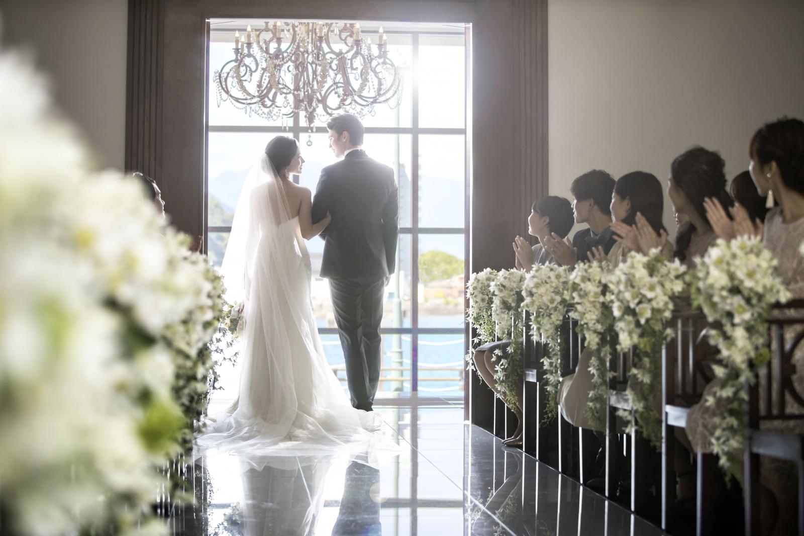 キラキラときらめくシャンデリアがおふたりを美しく演出しふたりを照らす自然光が印象的な入場・退場シーン