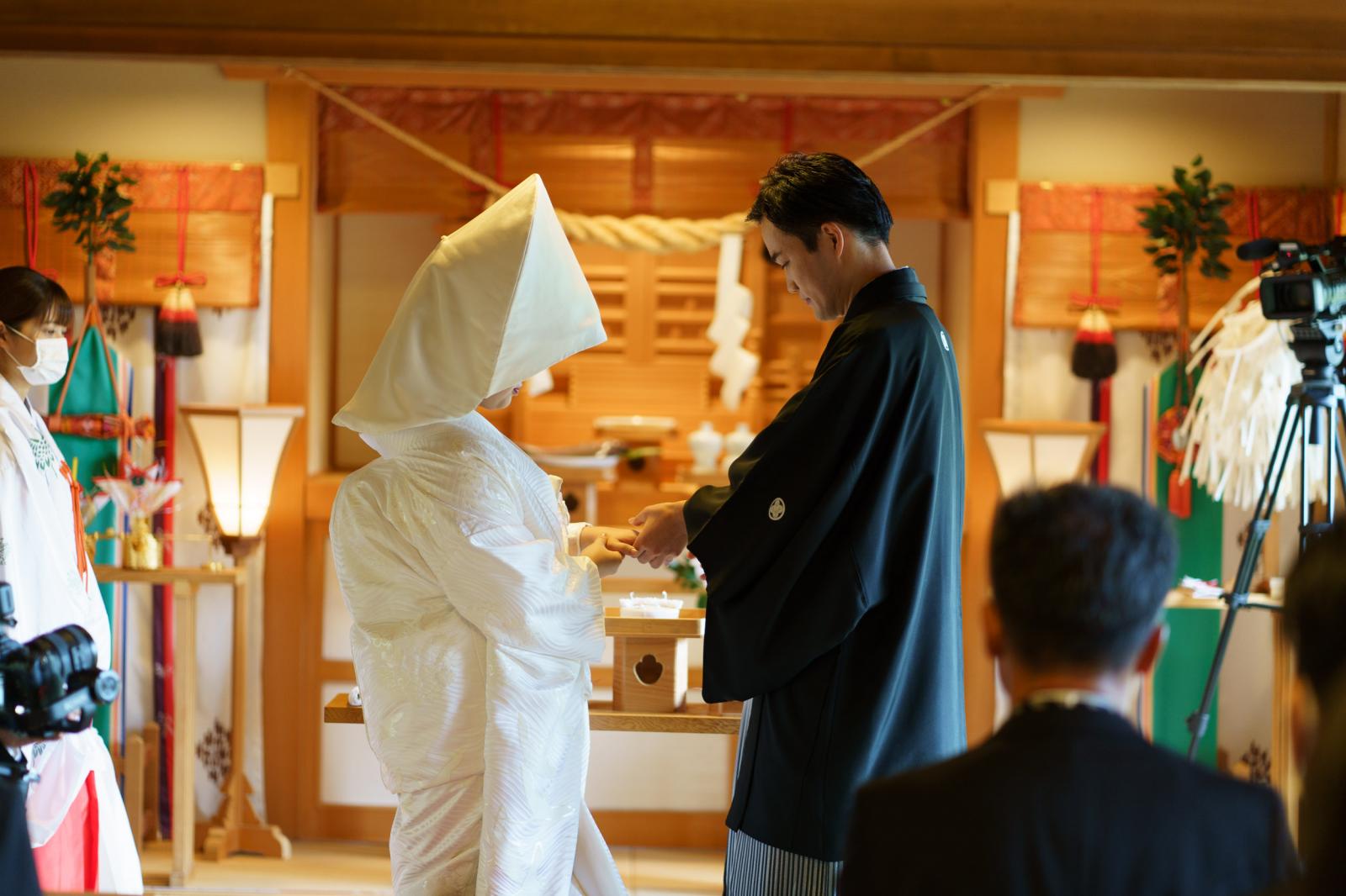 挙式は「神前式」。参列者に見守られながらの指輪交換