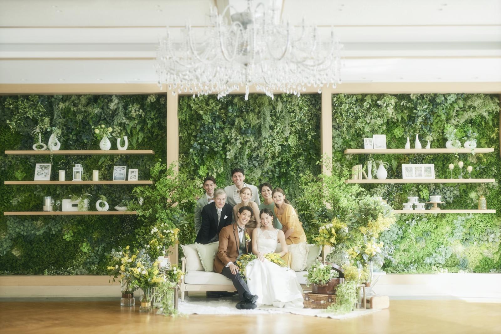 ソファスタイルのフォトブースは足元までドレスがきれいに映りこむ。印象的なグリーンウォールをバックに記念写真を。インナーガーデンは天候気候に左右されないのが喜ばれる。
