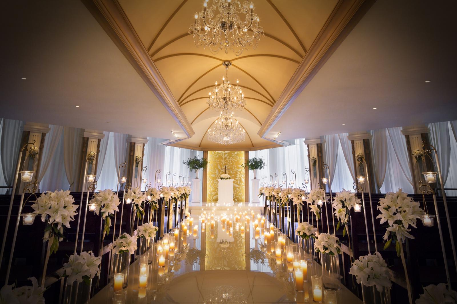 キャンドルの光がバージンロードに反射して輝くロマンチックな雰囲気。高級感のある上品な挙式会場コーディネートもオススメ